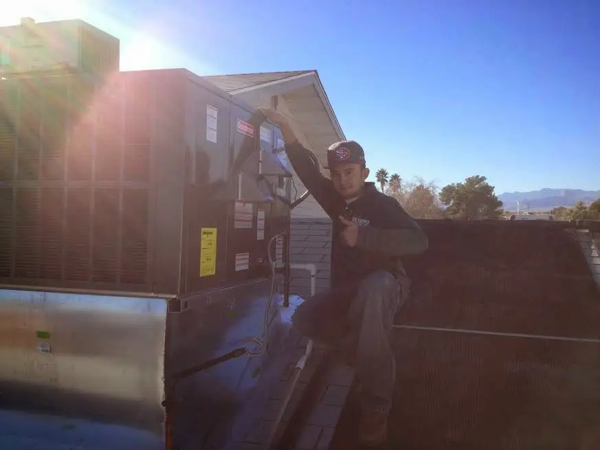 HVAC technician performing Air Duct Cleaning on a rooftop unit in Slidell